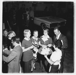 Catering staff person, Ed and Elinor Zumwalt, Jill Zumwalt and other attendees at the Zumwalt Chrysler-Plymouth Center Open House, Santa Rosa, California, 1971 (Digital Object)