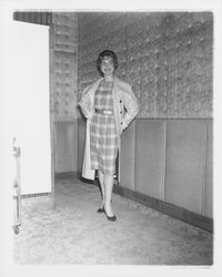 Model in plaid evening dress and a long coat in the &quot;Dramatic Moods&quot; fashion show in the Topaz Room, Santa Rosa, California, 1959 (Digital Object)