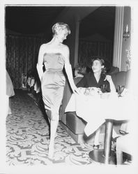Model in evening dress and Topaz Room customer in the &quot;Dramatic Moods&quot; fashion show in the Topaz Room, Santa Rosa, California, 1959 (Digital Object)
