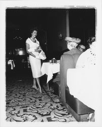 White calf-length dress modeled in the &quot;Dramatic Moods&quot; fashion show in the Topaz Room, Santa Rosa, California, 1959 (Digital Object)