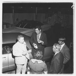 Ed Zumwalt talks to a group of people at the Zumwalt Chrysler-Plymouth Center Open House, Santa Rosa, California, 1971 (Digital Object)