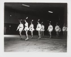 Line of skaters in white tunics and French military style hats in the Skating Revue of 1957, Santa Rosa, California, April, 1957 (Digital Object)