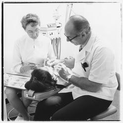 Unidentified dentist and assistant perform dental work on a patient in the Empire Dental Building, Santa Rosa, California, 1971 (Digital Object)