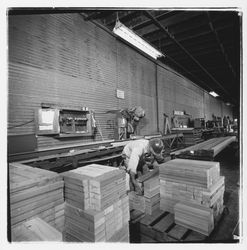 Worker stacking 2&quot; x 4&quot; fire-stop sections at Speedspace Corporation, 920 Shiloh Road, Windsor, California, 1971 (Digital Object)