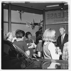 Group of people standing next to a new car at the Zumwalt Chrysler-Plymouth Center Open House, Santa Rosa, California, 1971 (Digital Object)