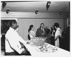 Catering staff member at a punch bowl, Cecilia Payne and other opening night attendees at Ceci&#39;s Flamingo Shop, Santa Rosa, California, 1957 (Digital Object)