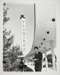 Man with notebook under portico of Flamingo Hotel, Santa Rosa, California, 1964 (Digital Object)