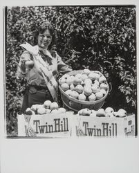 Apple Blossom Queen Julie Pimental posing with apple products, Sebastopol, California, 1977 (Digital Object)