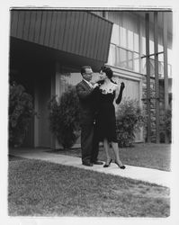 Unidentified man arranges a fur stole on Mrs. Willard Outlaw&#39;s shoulders at the Dramatic Moods of Autumn Fashion Show at the Flamingo Hotel, Santa Rosa, California, September 17, 1959 (Digital Object)