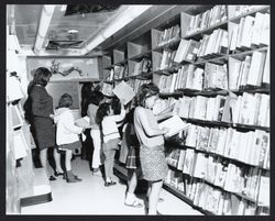 Children browsing the bookmobile shelves (Digital Object)