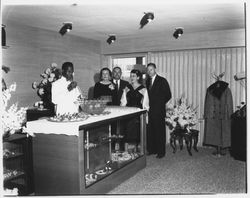 Catering staff member serves punch to Cecilia Payne and opening night attendees at Ceci&#39;s Flamingo Shop, Santa Rosa, California, 1957 (Digital Object)