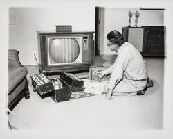 Bruner television technician repairing a TV in a home, Santa Rosa, California, 1964 (Digital Object)